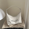Elegante bolso hobo crema con detalle de gancho metálico sobre fondo de felpa - Blanco