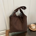 Braune Wildleder-Einkaufstasche mit Gingham-Futter und Schleife auf Holztisch - Braun