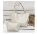 Detalle del bolso tote blanco crema con pequeño neceser a juego sobre un banco de madera - Blanco
