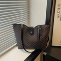 Sac fourre-tout marron avec motifs M et anses noires sur un rebord de fenêtre - Marron