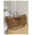 Detail of warm brown suede tote bag with leather trim on a wooden table in a cozy room - Khaki