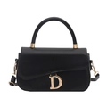 Elegante borsa a sella nera con ciondolo a D dorato e tracolla rimovibile su sfondo bianco - Nero