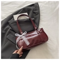 Détail d'un sac bandoulière en cuir rouge foncé brillant avec nœud en dentelle blanche - Rouge