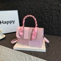 Sac bandoulière rose avec poignée enrubannée de soie et texture élégante sur livres - Rose