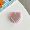 Macro view of a pink heart-shaped phone grip with built-in mirror and frosted edges - Deep Pink