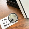 Detailed view of a round magnetic makeup mirror on a wooden desk with gift card - Black (Magnetic Base-gift Mirror)