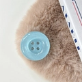 Close-up of a light blue glitter resin button phone grip on a brown fur texture surface - Pearlescent Blue