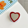 Detail of red glitter heart phone grip with built-in mirror and telescopic stand base - Brown