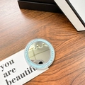 Macro detail of a round light blue portable makeup mirror with Gift For You decorative icons - Blue (Magnetic Base-gift Mirror)