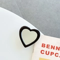 Macro di uno specchio per telefono a forma di cuore con bordo nero su sfondo chiaro - Supporto Trasparente-Specchio a Cuore con Bordo Jelly-Nero