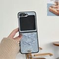 Detail of light blue textured folding phone case featuring 3D bows and gold emblem - Blue Bow Snakeskin Pattern / Samsung ZFlip3