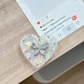 Detail eines herzförmigen Handyhalters mit Aurora-Perlentextur und blauem Edelstein-Schmetterling - Transparenter Ständer - Muschelherz Schmetterling - #9