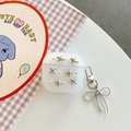 Dettaglio custodia AirPods glitterata con borchie a stella e ciondolo a fiocco metallico - Custodia Rotonda Per Auricolari - Glitter - Perline Argentate E Stelle Decorative - Con Ciondolo / AirPods 1ª/2ª generazione
