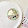 Detail eines runden hellgrünen Magnetspiegels mit rotem Good Luck Text auf einem Teller - Dunkelgrün