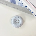 Macro shot of button-shaped phone grip with elegant black ink marble texture effect - White