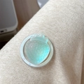 Detailed close-up of a pearlescent strawberry phone grip on beige knitted fabric - Iridescent Strawberry-Light Green