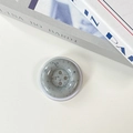 Detailed top view of a minimalist marble-pattern button phone socket on a white surface - Gray