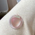 Close-up of a pink strawberry phone grip with leaf detail and embossed texture - Iridescent Strawberry-Brown