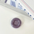 Macro shot of purple button-shaped phone grip with ink-splattered stone texture - Mauve