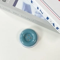 Detail view of the Morandi blue button phone grip showing its grainy texture and artistic design - Ink Blue