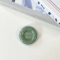 Macro detail of a green resin button phone socket with artistic black ink splash texture - Dark Green