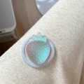 Macro view of a 3D translucent strawberry phone grip with iridescent finish on knit fabric - Iridescent Strawberry-Black