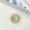 Close-up of mint green ink-splattered button phone grip on white decorative books - Light Yellow