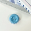 Macro detail of sky blue button-shaped phone grip with stone texture and four holes - Light Blue