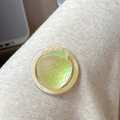 Close-up of a shimmering green strawberry magnetic phone stand with glitter details - Iridescent Strawberry-Yellow