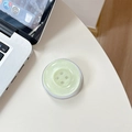Detail shot of light green glitter button phone socket on a white desk with laptop - Magnetic-Pearly Big Button / Light Green