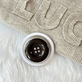 Gros plan du support magnétique bouton noir à quatre trous sur tricot beige doux - Noir