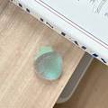 Supporto per telefono a fragola iridescente su tavolo in legno vicino a un libro - Nero Magico