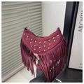 Detail of burgundy suede crescent bag with gold rivets and long fringe accents - Red