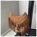 Detail of brown suede crescent bag featuring gold rivets and long fringe tassel decor - Brown