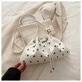 Close-up of white drawstring bucket bag featuring metallic stud details and premium texture - White