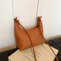 Minimalist caramel crescent shoulder bag with knotted strap on premium lychee texture - Brown