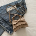 Elegante beige Schultertasche mit Schleife und geknoteten Griffen auf Denim Hintergrund - Khaki