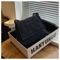 Detailaufnahme der schwarzen Stepptasche mit Rautenmuster und verstellbarem Schultergurt - Blau