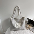 Minimalist white tote bag with M-letter print shown with a laptop and headphones - Off White