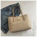 Detail view of beige corduroy tote bag showing metal rivets and textured brand patch - Dark Khaki