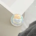 Close-up of a 3D cartoon bear acrylic phone grip with a cute pink party hat and blue bow - Dreamy Bubble Crystal Ball Style (85)