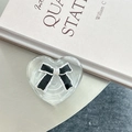 Close-up of heart-shaped phone grip with black bow on a minimalist desk surface - 3D Heart Stand - Bowknot Series - No. 14 Black