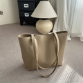 Bolso tote grande minimalista en color café claro sobre una alfombra gris con texturas - Caqui