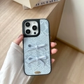 Detalle de funda azul claro textura serpiente con lazos y placa dorada Love is forever - Estampado De Piel De Serpiente Con Agujeros Grandes - 2 Lazos Atados A Mano - Azul / iPhone 17 Pro Max