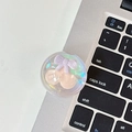Detail of transparent bear phone grip with 3D cherry and bow on a laptop keyboard - Crystal Ball Stand - Dreamy Bubble - No. 21