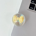 Macro shot of iridescent aurora yellow bow inside a clear grip tok on a desk - Crystal Ball Stand - Dreamy Bubble - No. 23