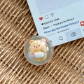 Detalle de un oso 3D con purpurina en un soporte redondo de resina para móvil sobre tapete - Burbuja de Ensueño Núm. 102