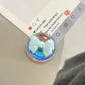Macro shot of a transparent phone grip with a 3D light blue ribbon design and resin finish - Dreamy Bubble Crystal Ball Style (94)