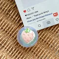 Detail of glitter resin phone grip featuring a 3D strawberry cake on a woven surface - Dreamy Bubble No. 105