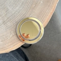 Close-up of champagne gold circular mirror MagSafe phone grip on a wooden surface - Mirror Magnetic - Round - Gold